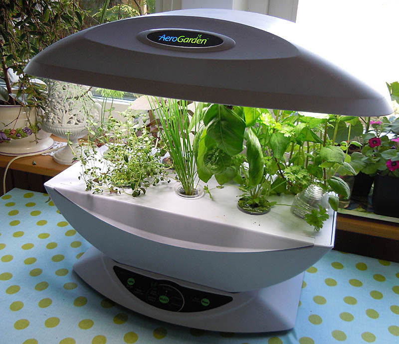 AeroGarden för enkel inomhusodling på köksbordet – LED-lampor, frökit och gödningstablett; odla kryddväxter som basilika, mynta, timjan och chili; höj lamporna vid tillväxt.