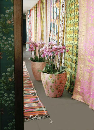 Bohemiskt vardagsrum med flera Phalaenopsis (brudorkidé) i färgad kruka på golvet, varma toner i rött, rosa och gult – höst och vinter inredning och stylingtips