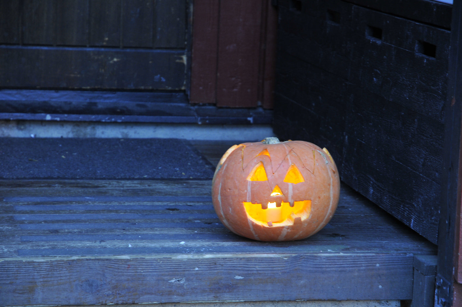 Svensk Halloween: lysande Jack-o’lantern-pumpa och höstpynt vid entrén, med rötter i keltiska Samhain och Allhelgonadagen; barnens bus eller godis.