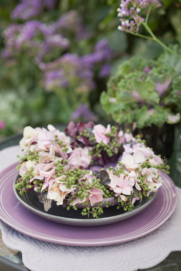 Fläder och hortensiakrans – blomkrans som bordsdekoration; sätt blommor tätt, bunden med bindtråd av grönt och krukväxter för livfullt säsongens blomarrangemang