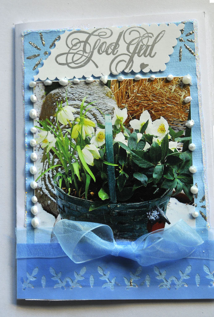 Handgjort julkort med julrosor: DIY pyssel. Tredelat kort i stadigt papper med utskuret fönster, foto monterat med limstift och dekorerat med band, stickers, pärlor, glitterpenna och stämplar.