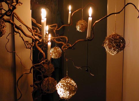 Vinter- och julinstallation: glasvas med glaskross och frostade glasstenar, dold ljusslinga och spegel som ljusspegel för skimrande ljusreflektion och fördubblad vinterstämning; naturmaterial och kreativ återbruk i hemmet.