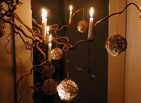 Vinter- och julinstallation: glasvas med glaskross och frostade glasstenar, dold ljusslinga och spegel som ljusspegel för skimrande ljusreflektion och fördubblad vinterstämning; naturmaterial och kreativ återbruk i hemmet.