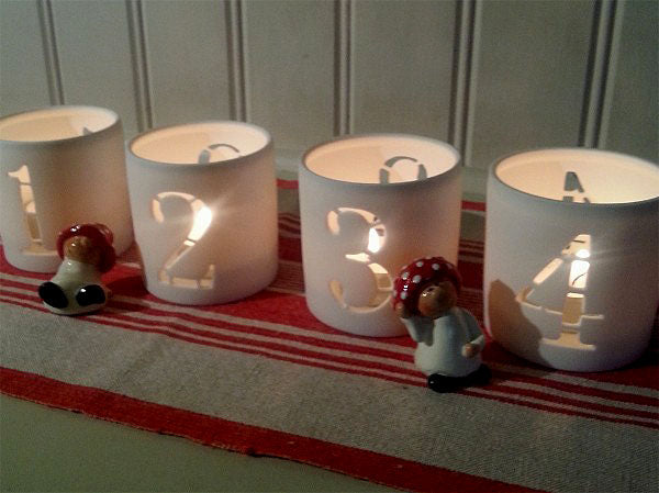 Siffror för advent på fyra adventsljus – julpynt i ljuslyktor som markerar första, andra, tredje och fjärde advent för stämningsfull adventsljusstake och mysig julstämning.